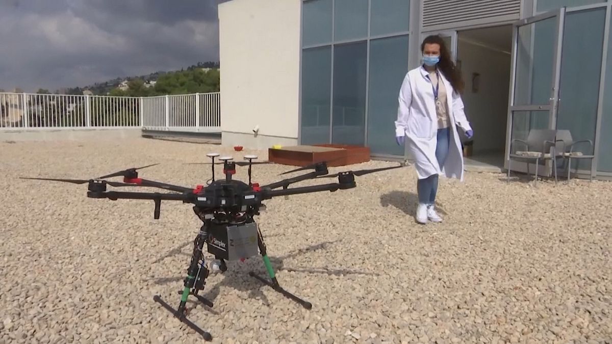Woman from medical staff taking box carried by drone