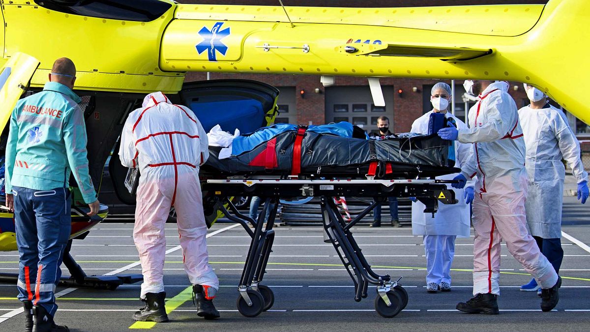 طاقم طبي يحمل على نقالة، مريض مصاب بفيروس كوفيد -19 على طائرة هليكوبتر من مستشفى فليفو في ألمير، إلى مونستر، ألمانيا، 23 أكتوبر 2020