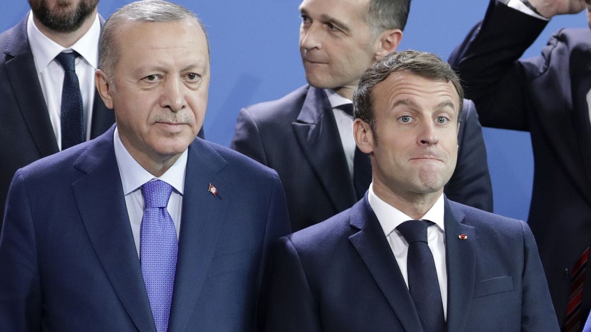 Turkey's President Recep Tayyip Erdogan, left and French President Emmanuel Macron stand, during a group photo at a conference on Libya in Berlin.