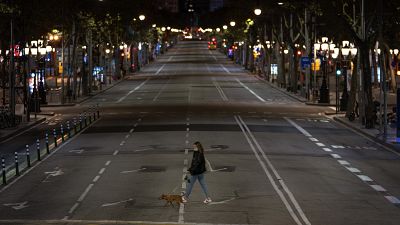 Una mujer cruza una calle vacía de Barcelona
