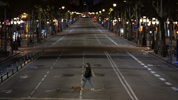 Una mujer cruza una calle vacía de Barcelona Una mujer cruza una calle vacía de Barcelona