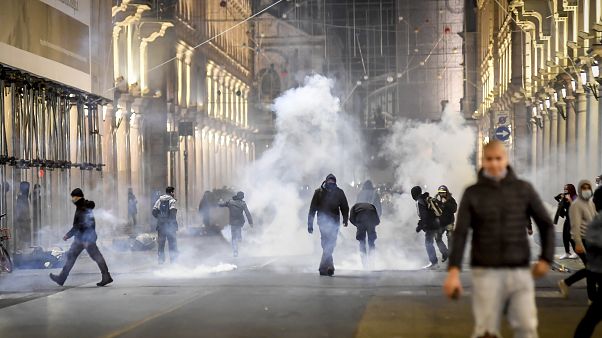 Smoke billows as clashes broke out during a protest against the government restriction measures to curb the spread of COVID-19 in Turin, Italy, Monday, Oct. 26, 2020. Smoke billows as clashes broke out during a protest against the government restriction measures to curb the spread of COVID-19 in Turin, Italy, Monday, Oct. 26, 2020.