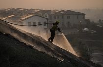 Firefighter Tylor Gilbert puts out hotspots while battling the Silverado Fire, Monday, Oct. 26, 2020, in Irvine, California, USA.