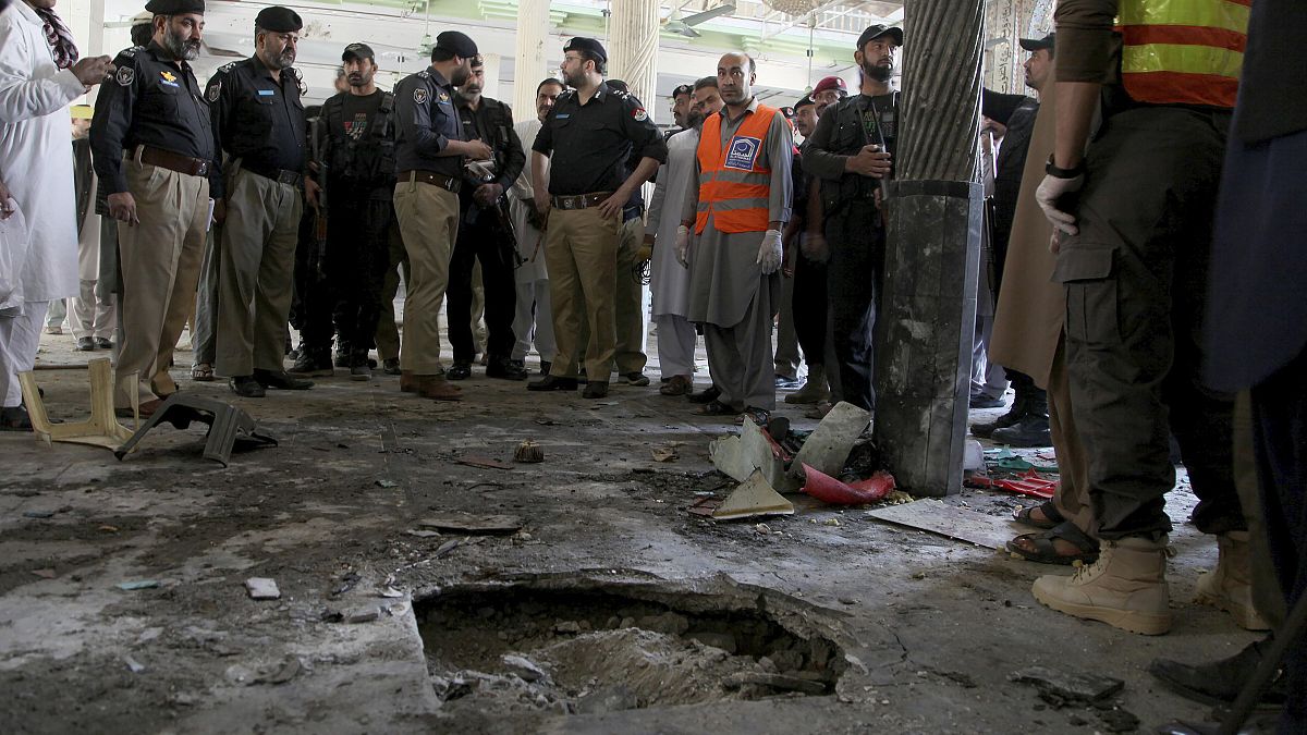Police officers examine the site of bomb explosion in an Islamic seminary in Peshawar, Pakistan, Tuesday, Oct. 27, 2020. 