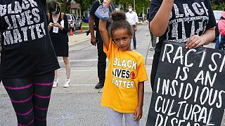 Six-year-old Deja holds her hand in the air during a Black Lives Matter protest Tuesday, Sept. 1, 2020, in Kenosha, Wis. 