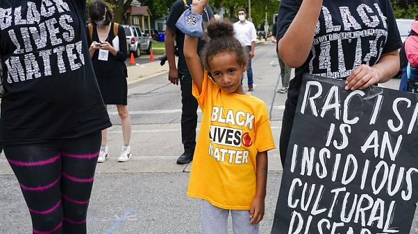 Six-year-old Deja holds her hand in the air during a Black Lives Matter protest Tuesday, Sept. 1, 2020, in Kenosha, Wis. Six-year-old Deja holds her hand in the air during a Black Lives Matter protest Tuesday, Sept. 1, 2020, in Kenosha, Wis.