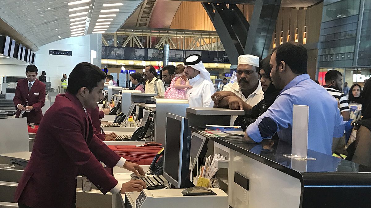 In this Monday, June 12, 2017 photo, Qatari and other nationals queue at the check in counters of the Hamad International Airport in Doha, Qatar