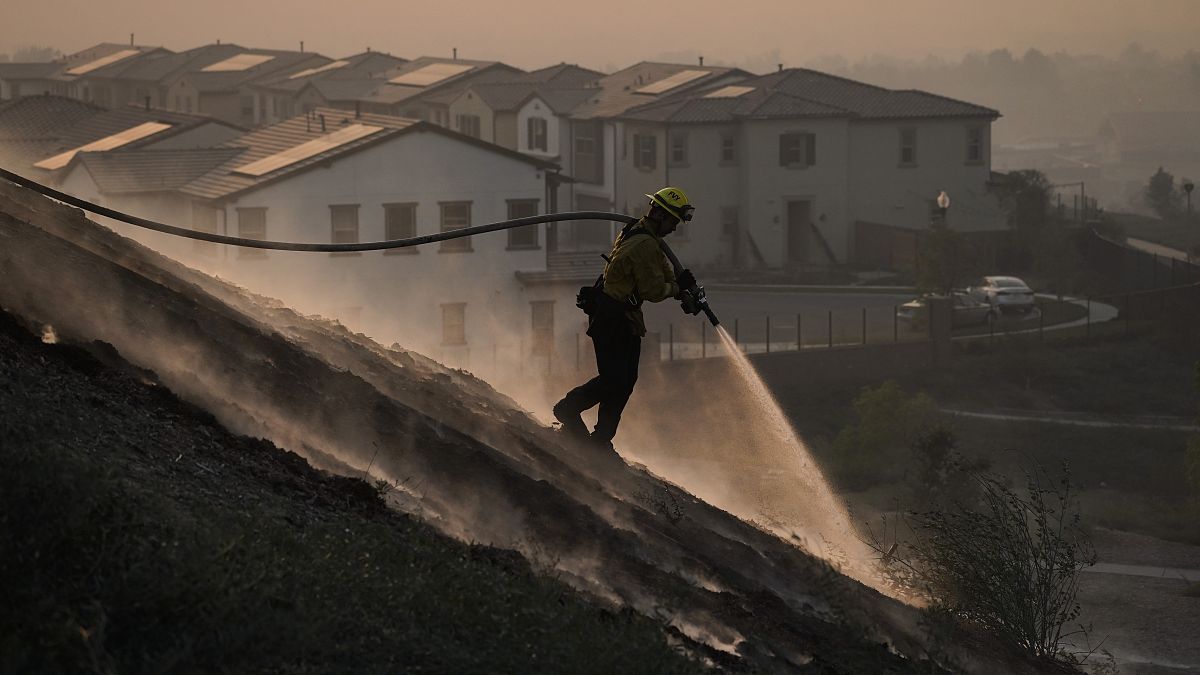 Ο πυροσβέστης Τάιλορ Γκίλμπερτ καταπολεμά εστίες της πυρκαγιάς Silverqdo Fire κοντά σε σπίτια στην νότια Καλιφόρνια