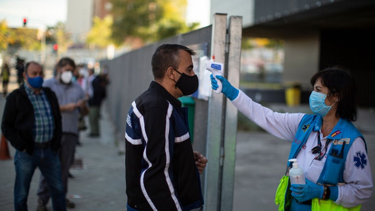 A Madrid Emergency Service (SUMMA) health worker checks the temperature of a man prior to a rapid antigen test for COVID-19 in Madrid. Oct 27, 2020