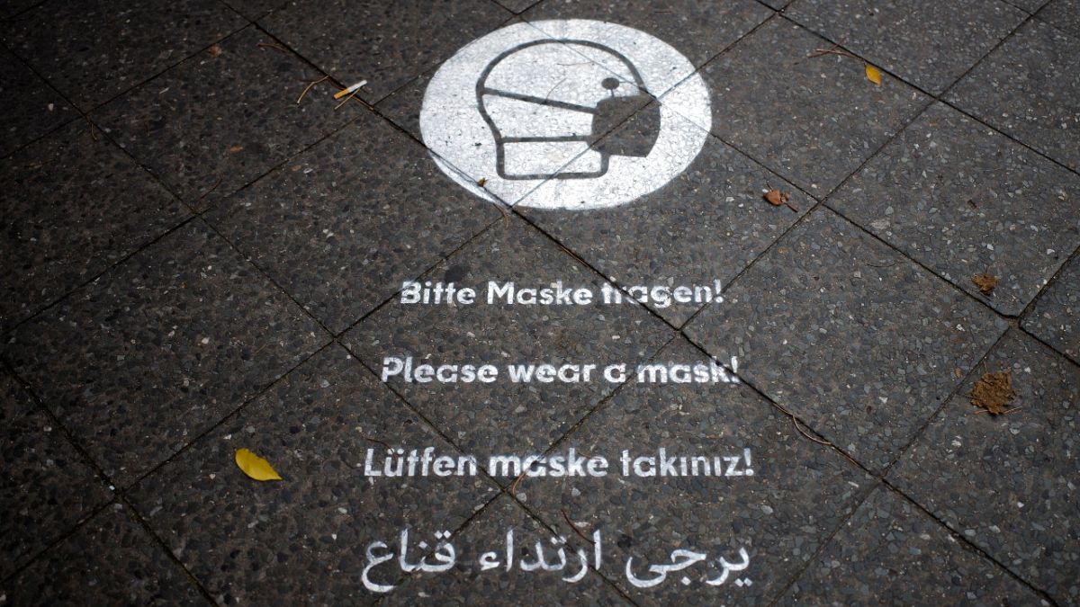 تذكير لارتداء الكمامات في أحد شوارع برلين. 