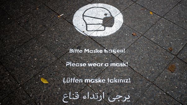 تذكير لارتداء الكمامات في أحد شوارع برلين. تذكير لارتداء الكمامات في أحد شوارع برلين.