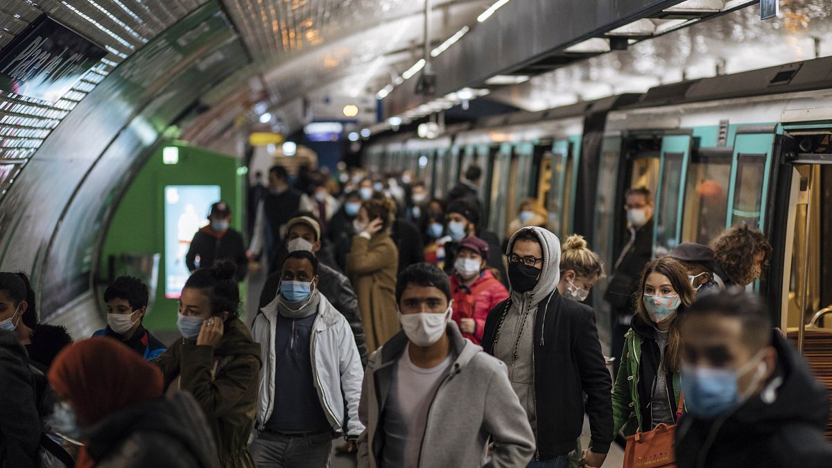 Pasajeros con mascarillas caminan por el andén de un metro de París, el domingo 25 de octubre de 2020. 