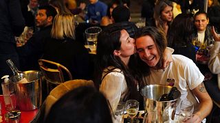 A couple kiss on the terrace of a restaurant before the nightly curfew due to the restrictions against the spread of coronavirus, in Paris, Friday, Oct. 23, 2020