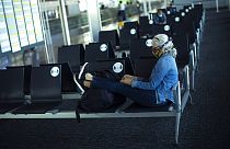 A passenger, wearing a face mask to protect against the spread of coronavirus, sits before boarding her flight at the Zaventem international airport