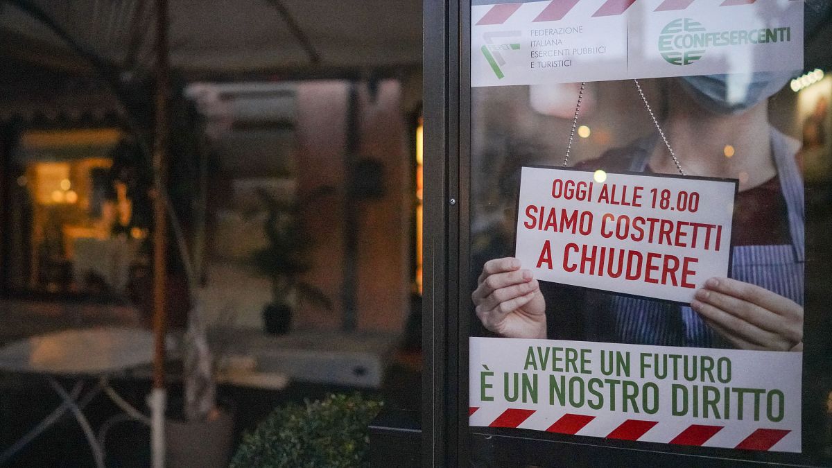 Une affiche sur laquelle est noté "aujourd'hui, nous sommes obligés de fermer à 18 heures"  sur la porte d'un restaurant de Rome, Italie, le 28 octobre 2020