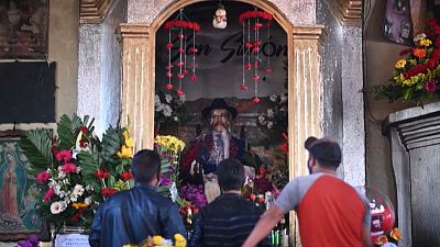 With alcohol and music, Guatemalans make offerings to folk saint San Simon