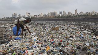 رجل يجمع البلاستيك في مومباي، الهند.