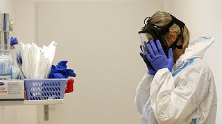 A health care worker puts on personal protective equipment (PPE) before tending to COVID-19 patients at an intensive care unit (ICU) at a hospital in Kyjov, Czech Republic.