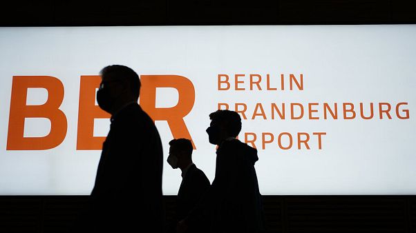 People walk in front of a sign of the new Berlin-Brandenburg-Airport 'Willy Brandt' in inside the Terminal 1, 27 Oct 2020 People walk in front of a sign of the new Berlin-Brandenburg-Airport 'Willy Brandt' in inside the Terminal 1, 27 Oct 2020