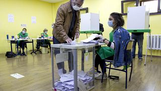 A man wearing a face mask to help curb the spread of the coronavirus, casts his ballot at a polling station during the parliamentary elections in Tbilisi, Georgia, Saturday, O