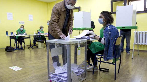 A man wearing a face mask to help curb the spread of the coronavirus, casts his ballot at a polling station during the parliamentary elections in Tbilisi, Georgia, Saturday, O A man wearing a face mask to help curb the spread of the coronavirus, casts his ballot at a polling station during the parliamentary elections in Tbilisi, Georgia, Saturday, O