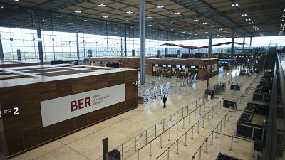 People walk through the Terminal 1 of the new Berlin-Brandenburg-Airport 'Willy Brandt' near Berlin in Schoenefeld, Germany, Tuesday, Oct. 27, 2020