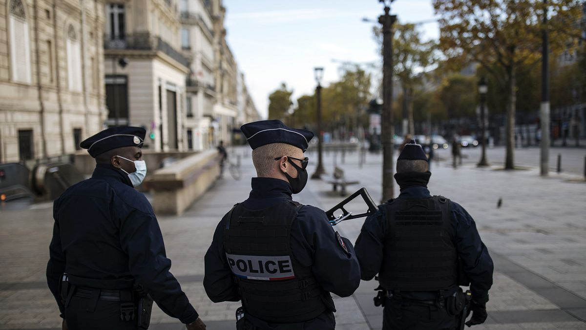 Police officers patrol the Champs Elysees avenue in Paris, Saturday, Oct. 31, 2020, the day after France imposed a new nationwide lockdown. 