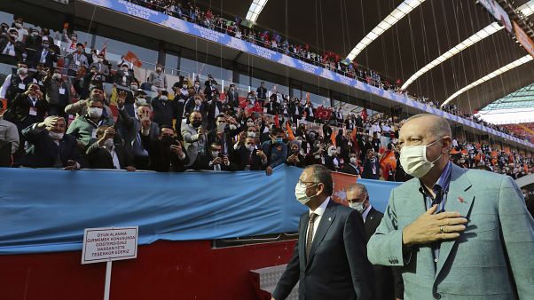 Turkey's President Recep Tayyip Erdogan, right, wearing a mask to help protect against the spread of coronavirus, greets his ruling party members gathered in a stadium, in Kay Turkey's President Recep Tayyip Erdogan, right, wearing a mask to help protect against the spread of coronavirus, greets his ruling party members gathered in a stadium, in Kay