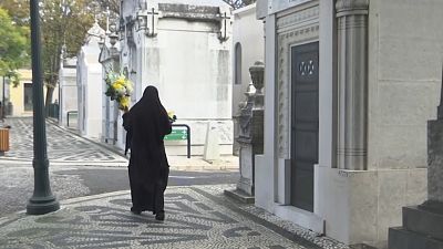 Woman passing by carrying flowers in Lisbon