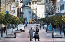 Maszkot viselő emberek sétálnak a Ticino tartományban található Bellinzonában 2020. október 27-én