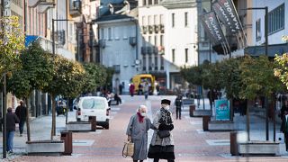 Maszkot viselő emberek sétálnak a Ticino tartományban található Bellinzonában 2020. október 27-én