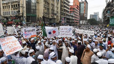 Protesters display placards during an anti-France demonstration in Dhaka