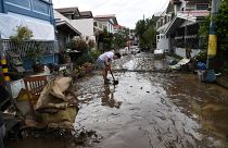 A resident shovels mud from a neighbourhood street following flooding in Batangas City.