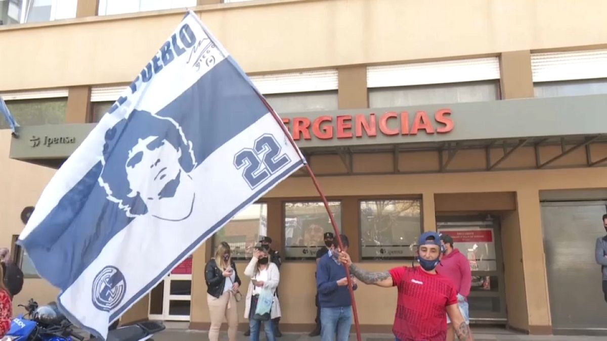 Un hincha ondea una bandera de Maradona a la entrada del hospital de La Plata