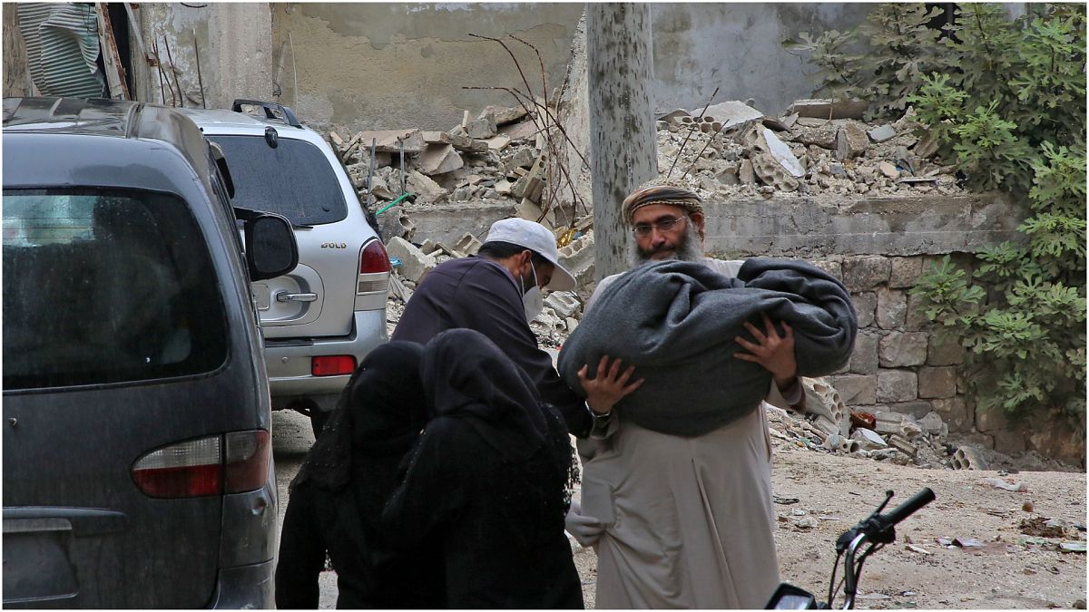 رجل يحمل جثة طفل قضى في القصف على إدلب