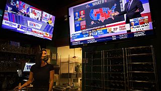 Bartender Sam Schilke watches election results on television at a bar and grill Tuesday, Nov. 3, 2020, in Portland, Ore. (AP Photo/Paula Bronstein)