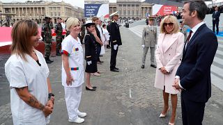 Le ministre français de la santé et Brigitte Macron saluent le personnel de santé lors du défilé militaire du 14 juillet 2020 à Paris.