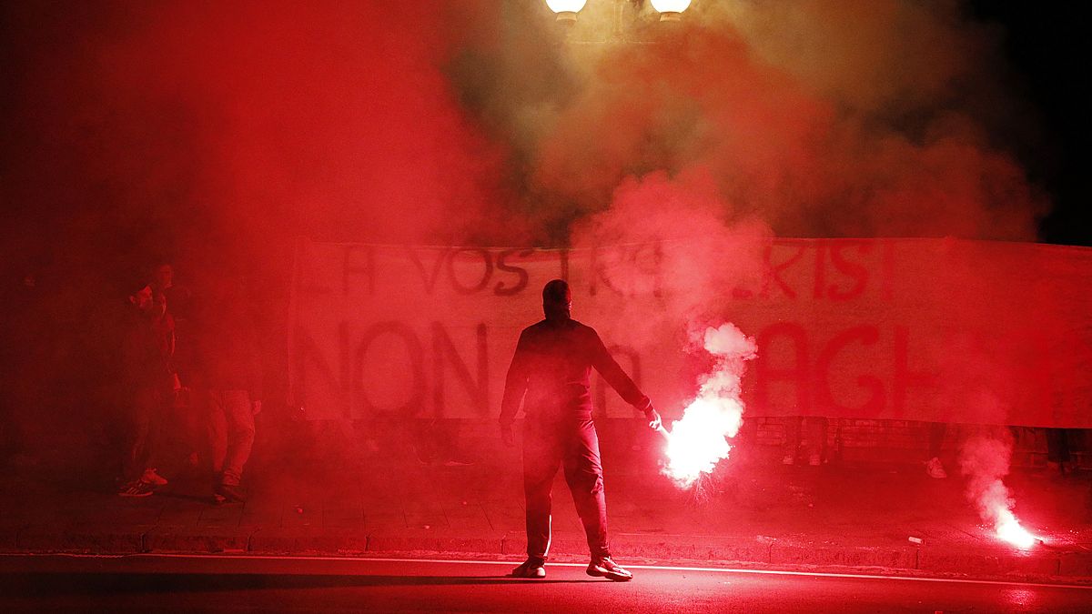 Demonstrators brandish flares and a banner during a protest against restriction measures imposed to curb the spread of COVID-19. Naples, Italy, Oct. 31, 2020