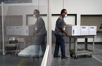 A county election worker moves boxes of counted ballots at a tabulating area at the Clark County Election Department in Las Vegas, Nevada.