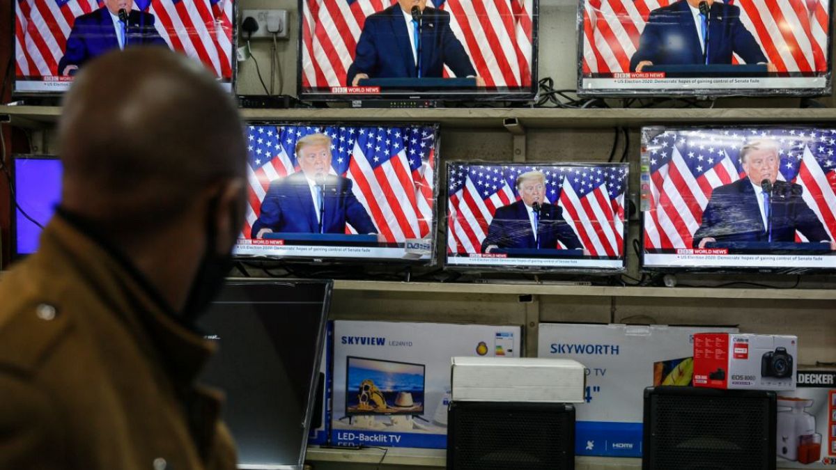 Un peatón observa la imagen de Trump repetida en las televisiones expuestas en un comercio