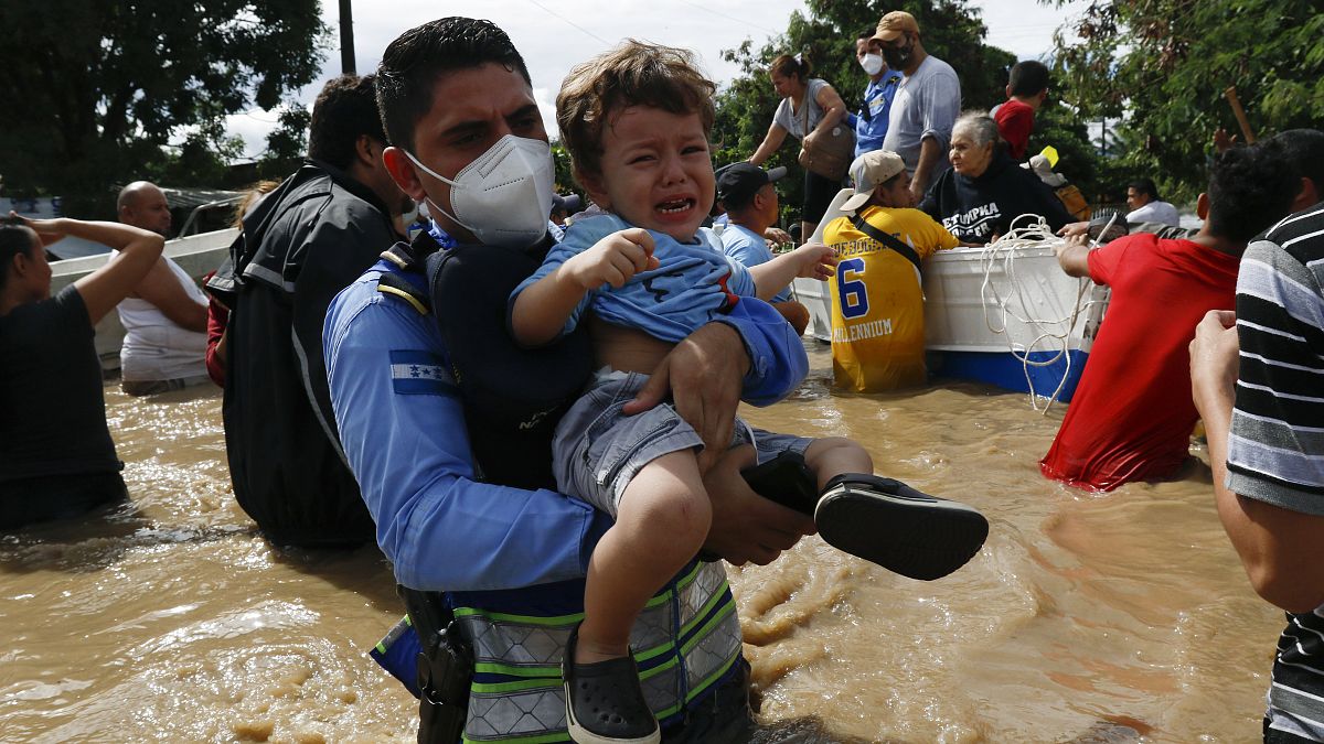Un niño es socorrido por los equipos de rescate en Honduras