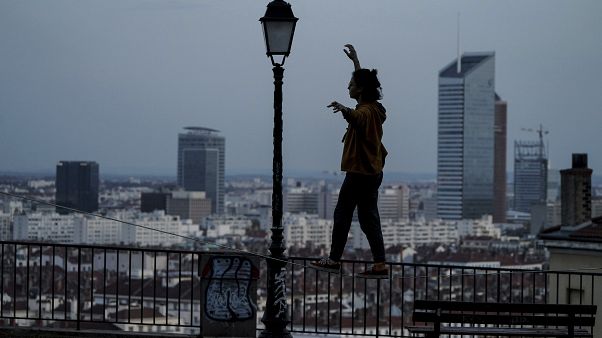 A woman balances on a railing on a hill above Lyon, France, which is in a monthlong partial lockdown A woman balances on a railing on a hill above Lyon, France, which is in a monthlong partial lockdown