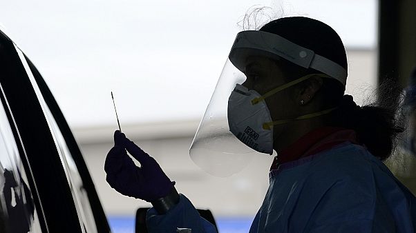 University of Washington research coordinator Rhoshni Prabhu holds up a swab after testing a passenger at a free COVID testing site in Seattle. University of Washington research coordinator Rhoshni Prabhu holds up a swab after testing a passenger at a free COVID testing site in Seattle.