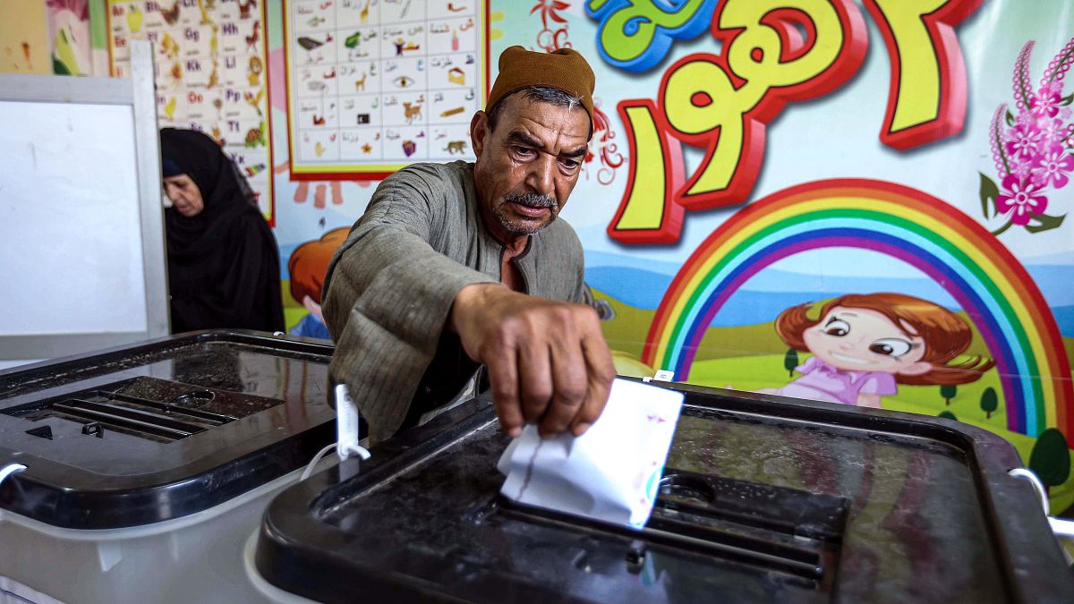 A man casts his ballot at a polling station in El-Ayyat, south of the Egyptian capital on October 24, 2020