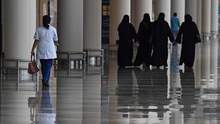 Emirati women walk in a nearly deserted shopping centre during the novel coronavirus pandemic crisis in the Gulf Emirate of Dubai, on April 19, 2020.