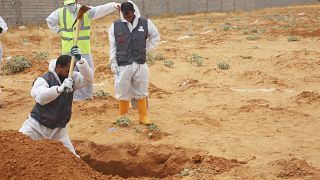 Libyan Ministry of justice employees dig out at a siyte of a suspected mass grave in the town of Tarhouna, Libya, Tuesday, June 23, 2020.