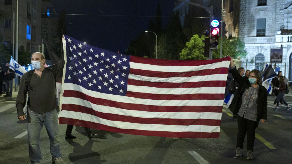 Manifestantes israelitas seguram bandeira dos EUA após vitória de Biden