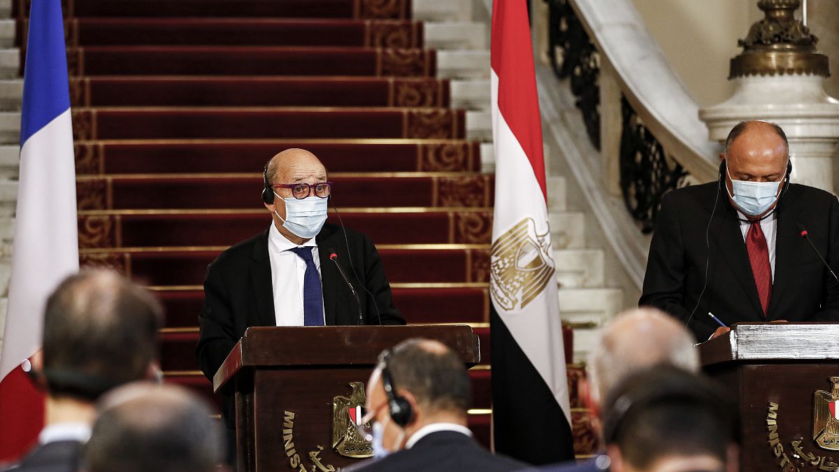France's Minister of Europe and Foreign Affairs Jean-Yves Le Drian (L) and Egyptian Foreign Minister Sameh Shoukry (R), mask-clad due to the COVID-19 coronavirus pandemic