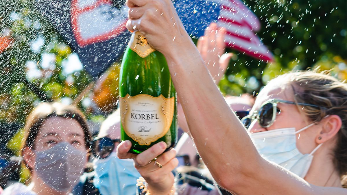 Happy voters pop champagne in Washington DC after Joe Biden wins presidential election.