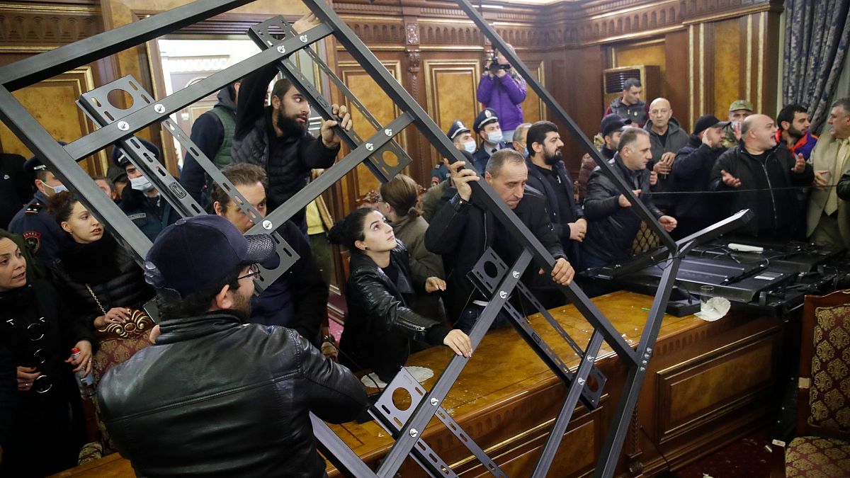 People crash a construction as they broke into the government building protesting against an agreement to halt fighting over the Nagorno-Karabakh region, in Yerevan, Armenia